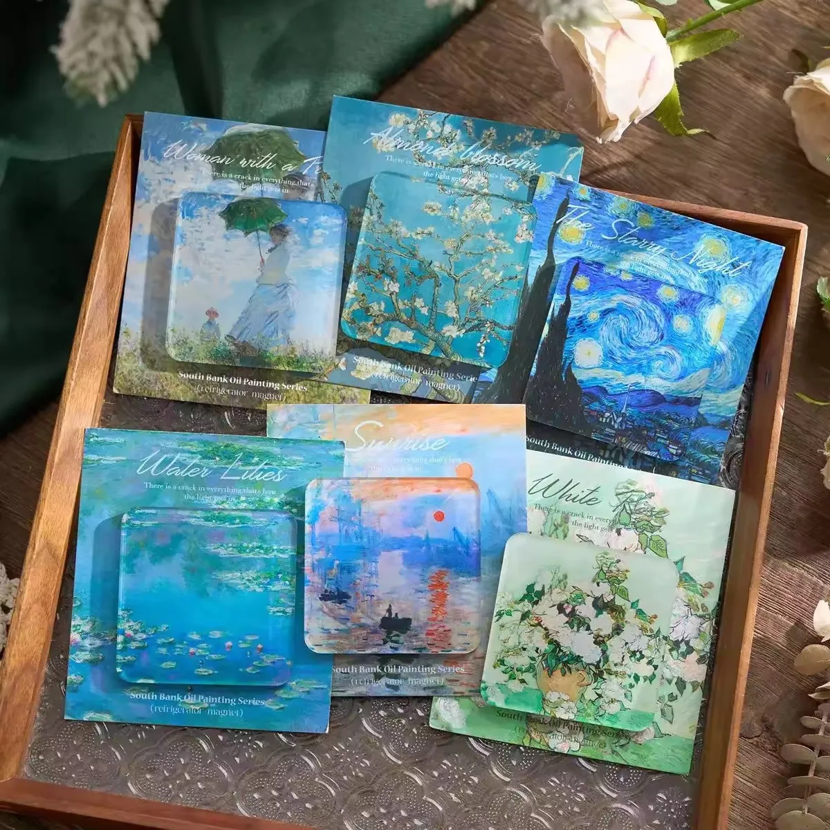 Acrylic fridge magnets, each mounted on a printed backing card sized slightly larger than the magnet, arranged in a tray