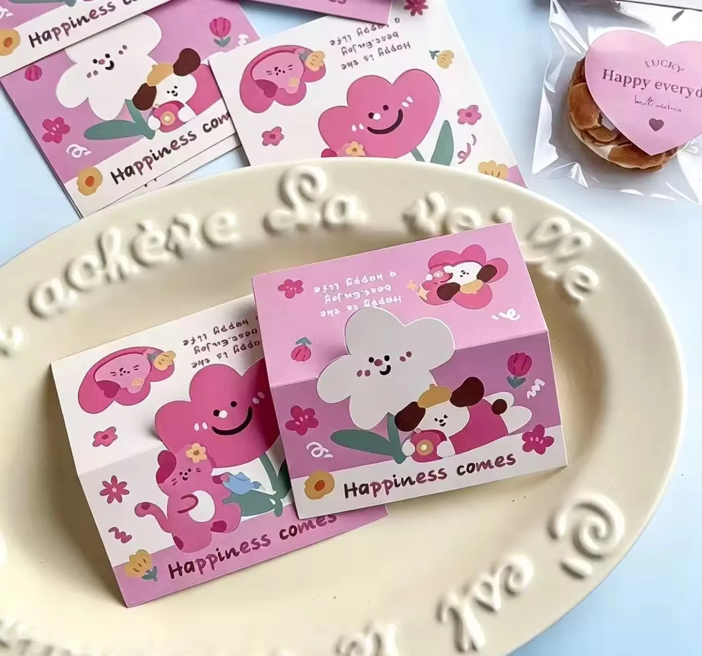 Custom sticker packs in clear poly bags with printed header cards stapled on top, with loose die-cut stickers beside them