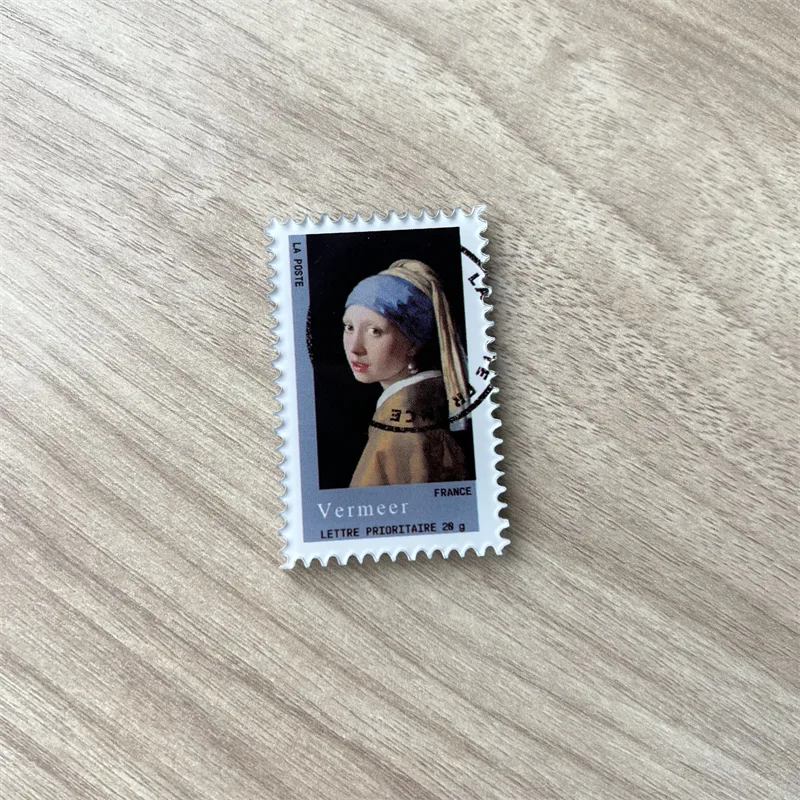 Fridge magnet shaped like a perforated postage stamp printed with a Vermeer painting