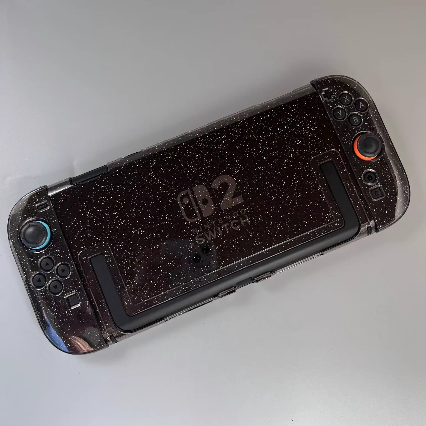 Smoke-black glitter protective shell fitted to a Nintendo Switch 2 console